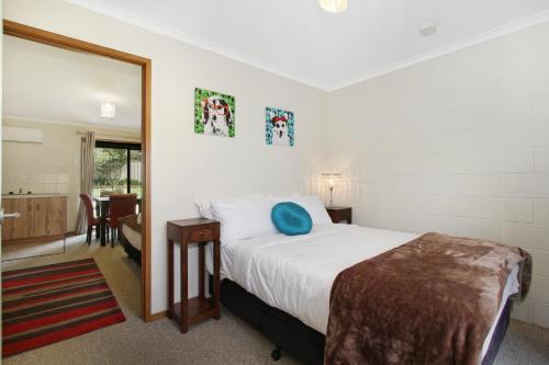 a bedroom with a bed with a blue pillow on it at Beechworth On Bridge Motel in Beechworth