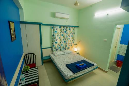 a small bedroom with a bed and a chair at Sree Theja Residency in Anantapur