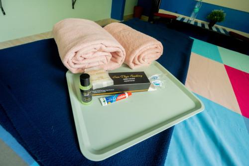 a tray with a towel and a book on a bed at Sree Theja Residency in Anantapur