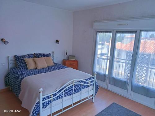 une chambre avec un lit et une grande fenêtre dans l'établissement Joli appartement à la mer, à La Tranche-sur-Mer