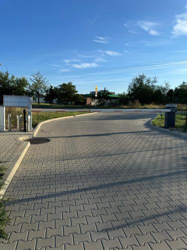 an empty parking lot with a brick road at Komfortowy Apartment z jedną sypialnia 60m kw Lokalizacja Poznań Baranowo in Poznań