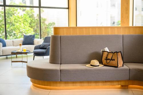 a couch with a hat on it in a room at Kinar Galilee in Kinar
