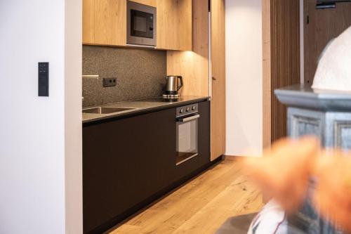 a kitchen with a sink and a stove top oven at Aparthotel Zum Schlössl in Villa Ottone