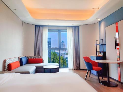Una habitación de hotel con una cama, un sofá y una ventana. en Holiday Inn Express Beijing Conference Center by IHG, en Beijing