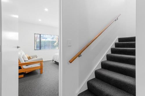 a staircase in a house with a white wall at Gather Taupo - Lakeview - Spa Pool in Taupo