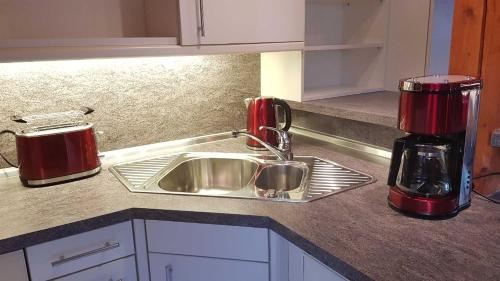 a kitchen counter with a sink and a appliance at Ferienwohnung Schwarz in Gasseldorf