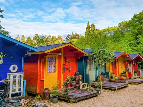 a row of colorful houses sitting next to each other at 星逢える宿ー森のコテージ気仙沼 in Kesennuma