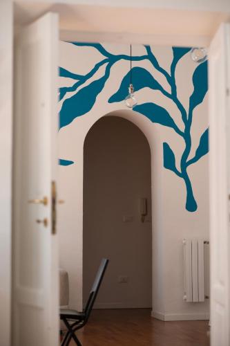a hallway with a blue tree mural on the wall at Il colibrì in Pescara