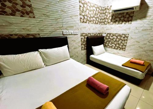 a hotel room with two beds and a couch at Damansara Damai Hotel- DD in Petaling Jaya