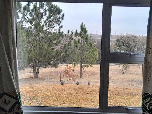 a window with a view of a field with trees at Woburn Guest House in Chartwell