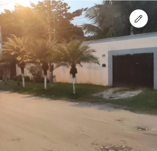 a group of palm trees in front of a building at Suíte Coqueiro CasaMar hospedagem in Bertioga