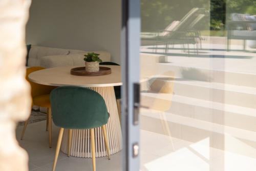 a room with a table and a green chair at Bella vista - Un air de toscane in Portes-lès-Valence
