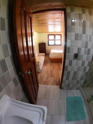 a bathroom with a sink and a bed in a room at Hospedaje Villa Valencia en Los Patos in Los Patos