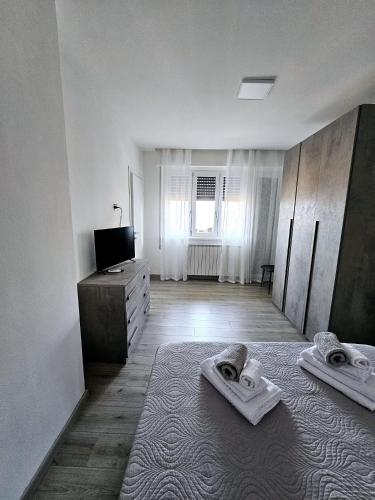 a white room with two towels on a bed at Lake View in Meina