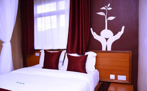 a bedroom with two beds and a drawing of a person with a plant on at Divine Homes Resort Kisumu in Kisumu