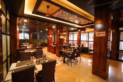 a restaurant with tables and chairs in a room at Ramana Towers in Tiruvannāmalai