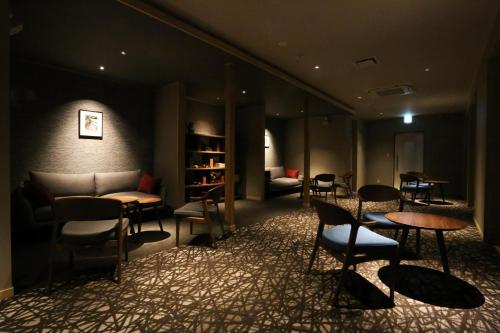 a lobby with chairs and tables and a couch at Saito Hotel in Ueda