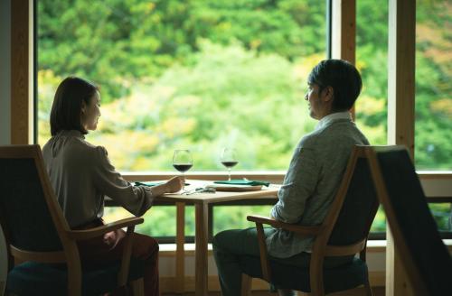 two people sitting at a table with wine glasses at Saito Hotel in Ueda