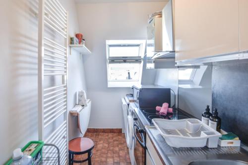 une petite cuisine avec un comptoir et un évier dans l'établissement Sur la Promenade Proust - Appt vue mer, à Cabourg