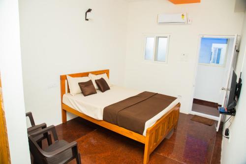 a bedroom with a bed and a television in it at Orange Residency in Tirupporūr