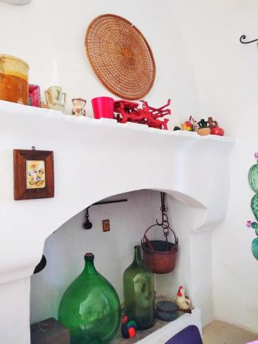 a room with two green glass vases on a shelf at Masseria delle Rose 1760 in Alessano