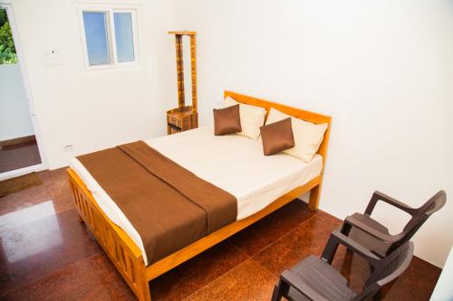 a bedroom with a bed and a chair in it at Orange Residency in Tirupporūr