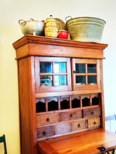 a wooden cabinet with dishes on top of it at Masseria delle Rose 1760 in Alessano