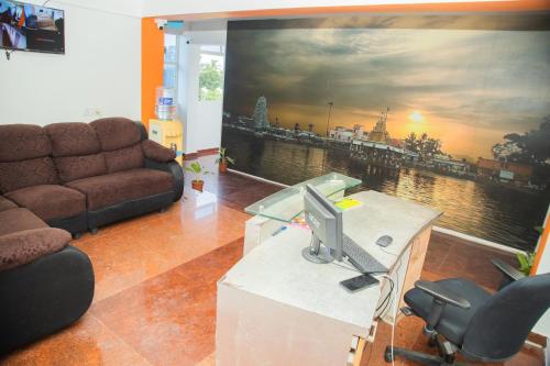 a living room with a large painting on the wall at Orange Residency in Tirupporūr
