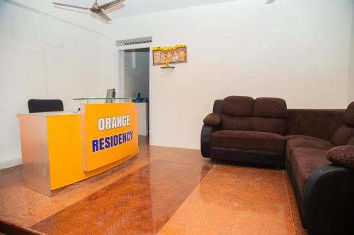 a living room with a table and a couch at Orange Residency in Tirupporūr