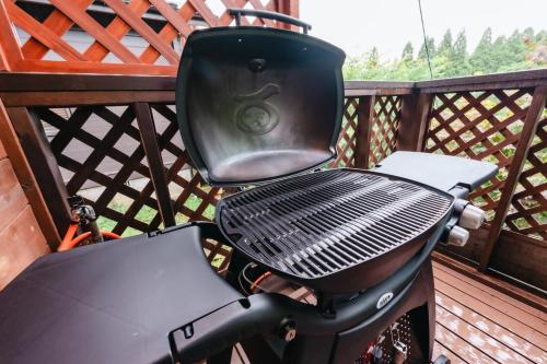 a grill sitting on a deck with a grill at Kurokawa Mori No Kiki in Minamioguni