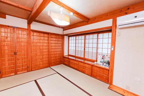a room with wood paneling and a window at Kurokawa Mori No Kiki in Minamioguni