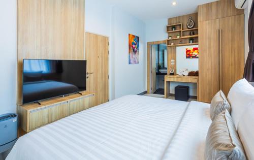a bedroom with a bed and a flat screen tv at "Smooth as Silk" Gorgeous 3-Bedroom Pool Villa, Just a Stone's Throw from the Beach! in Ban Khlong Haeng