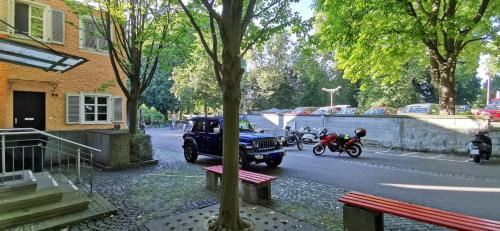 a car driving down a street with a person on a motorcycle at Apartment mit Parkblick Lindau Bodensee Insel in Lindau