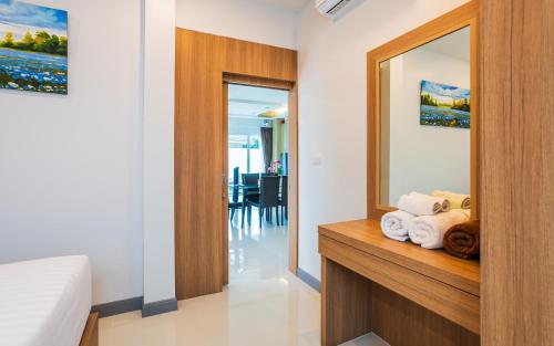a bedroom with a mirror and a bed with towels at "Smooth as Silk" Gorgeous 3-Bedroom Pool Villa, Just a Stone's Throw from the Beach! in Ban Khlong Haeng