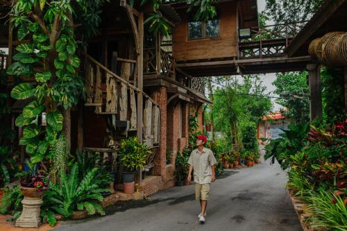 a man walking down a street in front of a building at Klong Suan Plue Resort in Phra Nakhon Si Ayutthaya