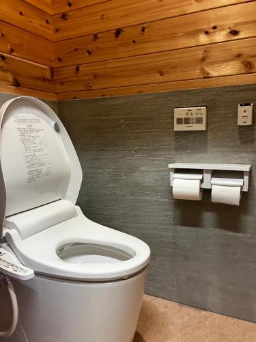 a bathroom with a toilet and two rolls of toilet paper at 交流宿　星降る家　いこい in Gujo