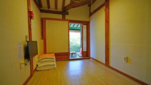 an empty room with a wooden floor and a large window at Sarangroo in Jeonju