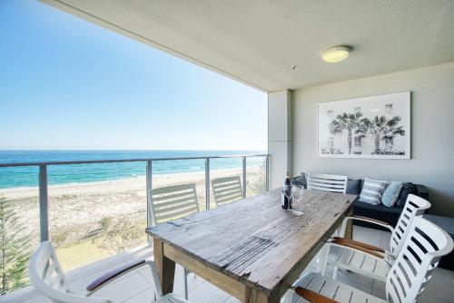 a dining room with a table and a view of the beach at Absolute Kirra by EcoTime in Gold Coast