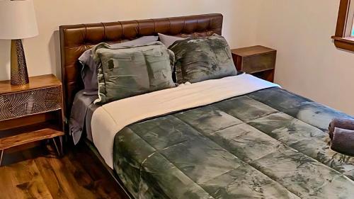 a bedroom with a large bed with green comforter and pillows at Kids under 4 free, Jacuzzi, Sauna, Pool, Lake, Gym in Albrightsville