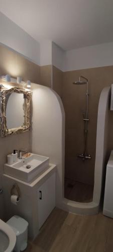 a bathroom with a sink and a toilet and a mirror at Naxian Purity in Glinado Naxos