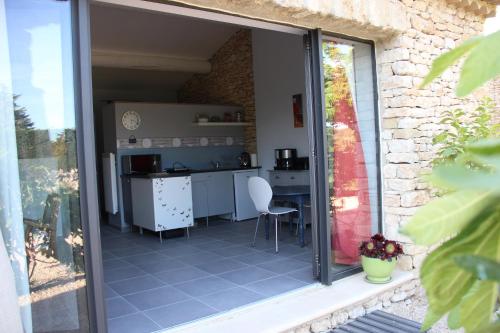 vista su una cucina attraverso una porta scorrevole in vetro di La cigale bleue a Gordes