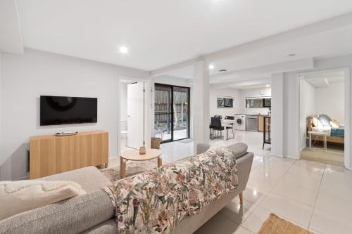 Una sala de estar con un sofá y un televisor. en Sunset Seaside Sanctuary, en Mornington