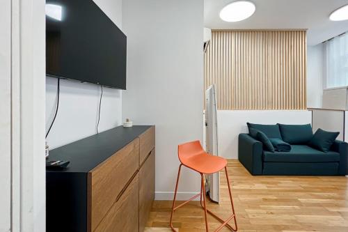 un salon avec un canapé bleu et une chaise dans l'établissement Nice 2 rooms near the Place de la Nation, à Paris