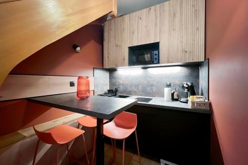 une cuisine avec une table noire et des chaises orange dans l'établissement Nice 2 rooms near the Place de la Nation, à Paris