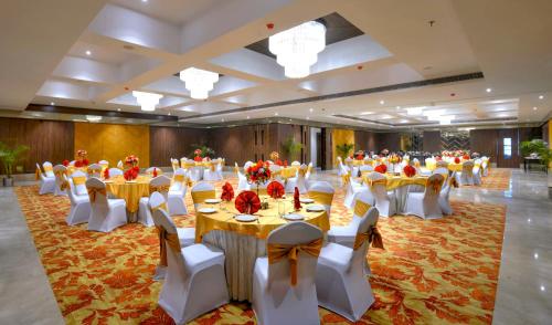 a banquet hall with tables and chairs in a room at Golden Tulip Agra in Agra
