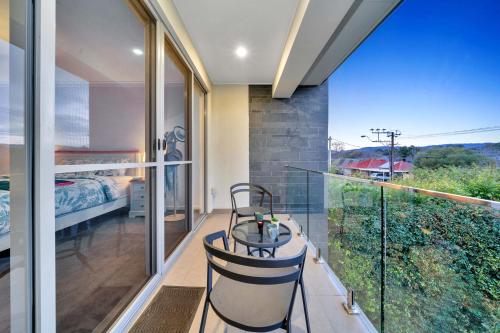 a room with a balcony with a bed and a desk at Luxury on City Fringe in Klemzig By Elegant Stays in Campbelltown