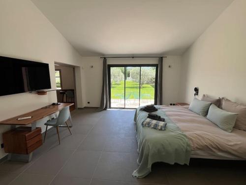 une chambre avec un lit, un bureau et une télévision dans l'établissement Villa Domitia Splendid View 5mn walk from center of Saint Remy, à Saint-Rémy-de-Provence