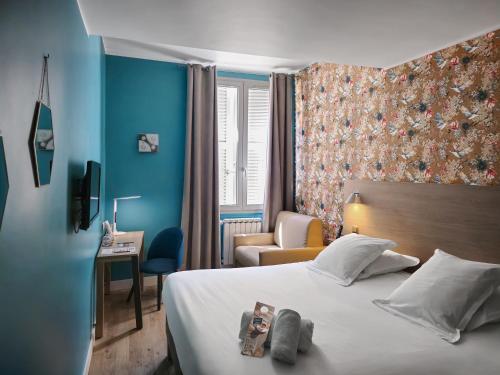 a hotel room with a bed and a chair at Grand Hôtel Dauphiné Toulon, Boutique Hôtel & Suites in Toulon
