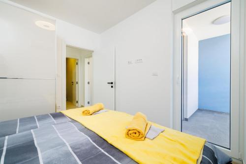 a bedroom with a yellow bed with a large mirror at Schmidt veliki in Dramalj