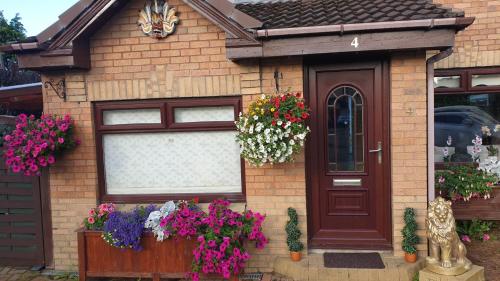 a house with flowers on the side of it at Ceylon HomeStay in Knightswood